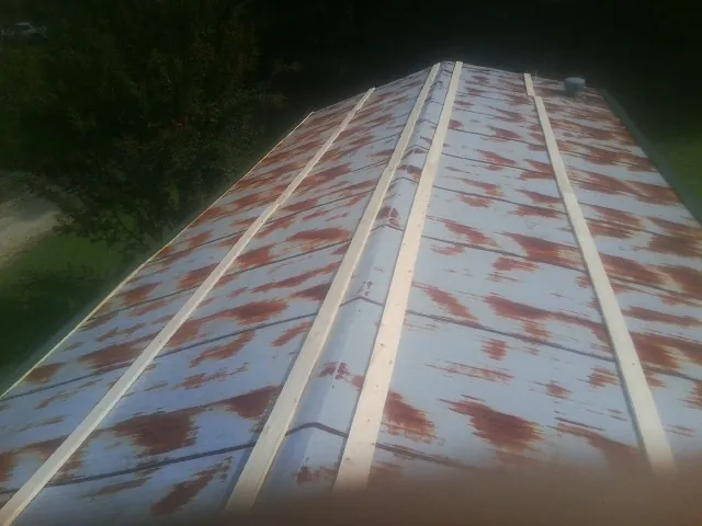 Rusted metal roof panels with new wood purlins before replacement — Storm Damage Roof Repair in Bourbon by Roofing Brothers